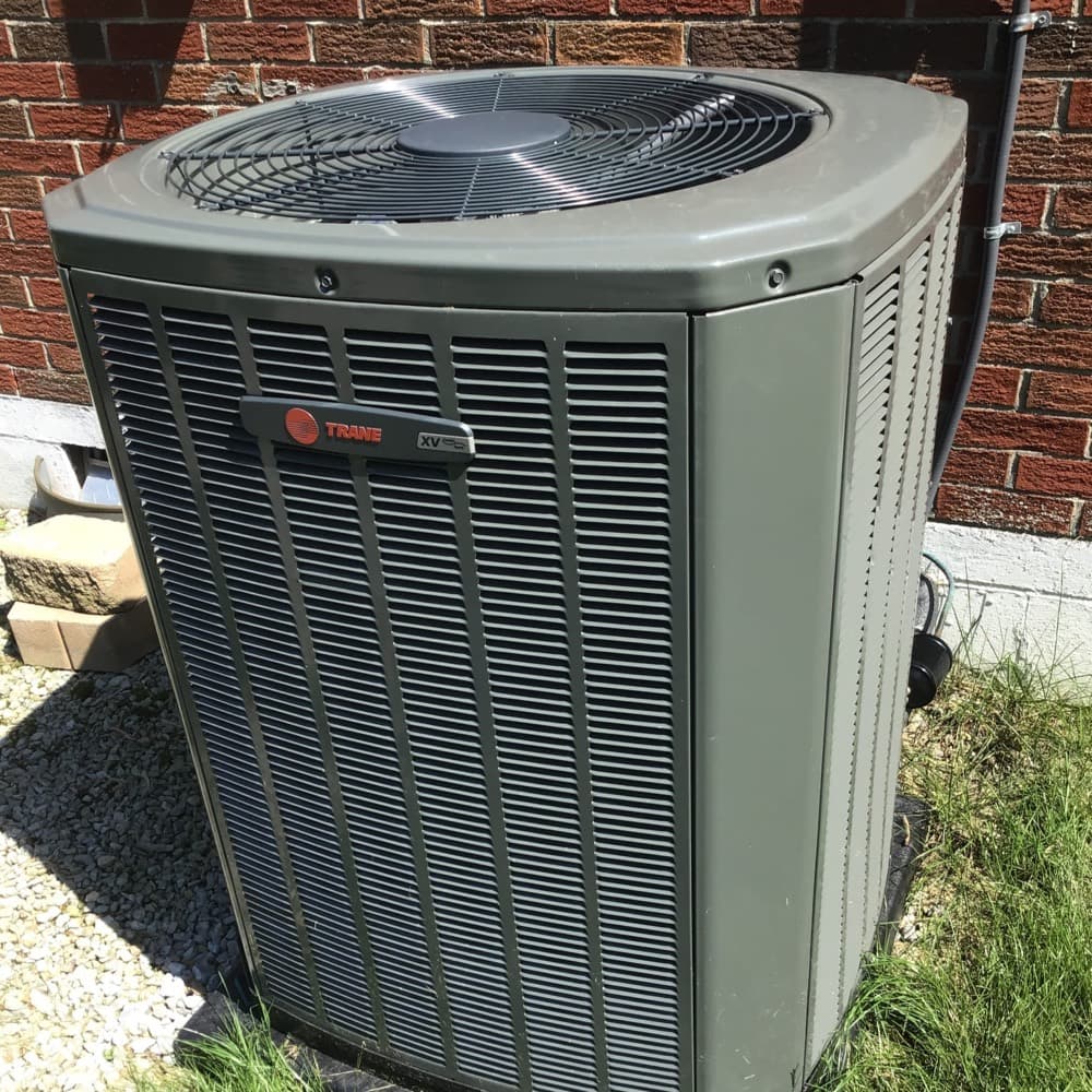 Trane outdoor condenser beside a brick wall