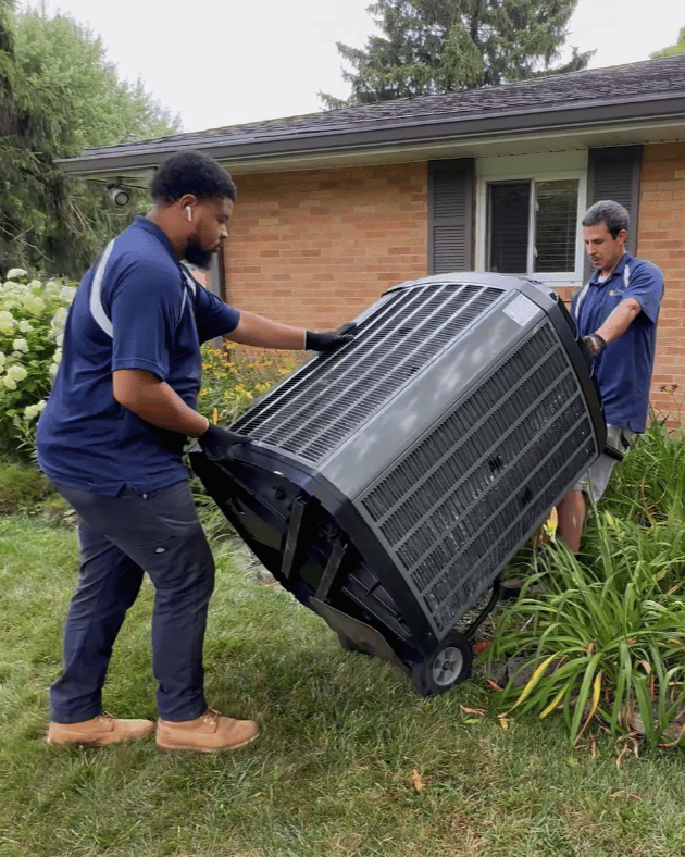 HVAC crew moving an outdoor air conditioner condenser at a GTA home